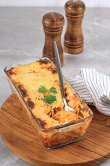 Wall Mural - Close Up Spaghetti Brulle on Clear Baking Dish l with Staiinless Spoon and Fork. Spaghetti Brulee is Baked Spaghetti with Bechamel and Bolognese Sauce