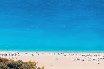 Wall Mural - Aerial view of a white idyllic beach in a resort town washed by the bright turquoise Mediterranean sea