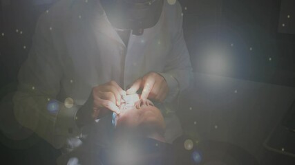 Poster - Spots of light against male doctor operating eyes of female patient