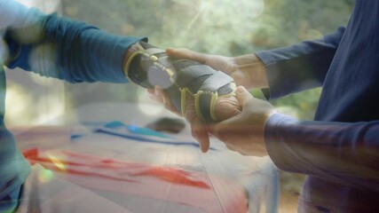 Poster - Spots of light against mid section of man putting hand strap on womans hand