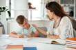 © JustLife - Mother helping her son with homework at home. Little boy learning at home...