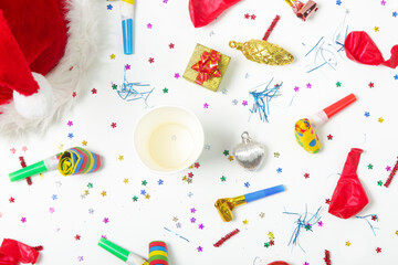 Christmas and New Year decorations with confetti, gift boxes, Santa Claus hat and party blowouts. Colorful party flat lay.