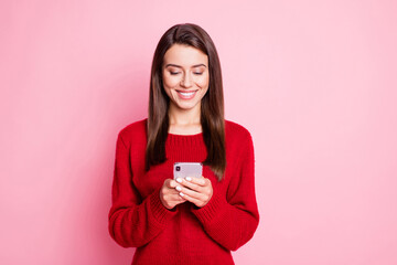 Wall Mural - photo of pretty young lady hold telephone look screen white smile wear red sweater isolated pink col