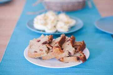 Canvas Print - Closeup of cranberry bread and freshly cut eggs with mayonnaise on separate blue plates