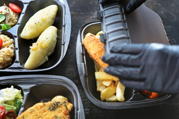 Dietary catering. The cook puts the dish in a container. A set of balanced dishes in styrofoam containers. Takeaway.