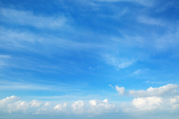 A clear blue sky with white clouds