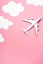 Top View Of White Plane Model On Pink With Clouds