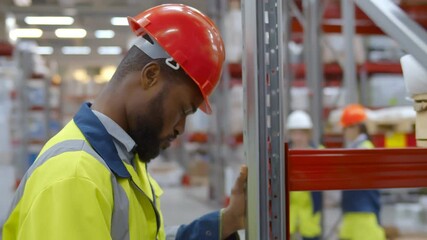 Wall Mural - Exhausted african worker hitting head in hardhat against shelf in warehouse