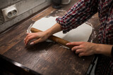 Fototapeta  - female hands roll out pizza dough