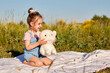 © aitorserra - little girl playing with stuffed animal in the meadow