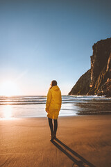 Woman tourist walking alone on beach traveling alone outdoor freedom mental health concept vacations trip eco tourism in Norway