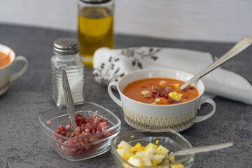 Sticker - Closeup of delicious Salmorejo soup served with ham in a white bowl with a spoon on a table