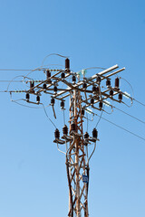 Poster - Vertical closeup of an electrical tower under the blue sky