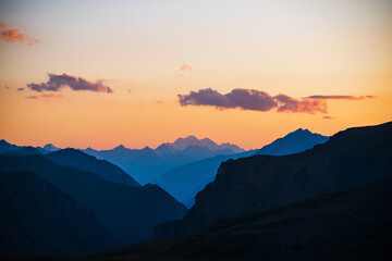 Wall Mural - colorful dawn landscape with beautiful mountains silhouettes and golden gradient sky with lilac clou