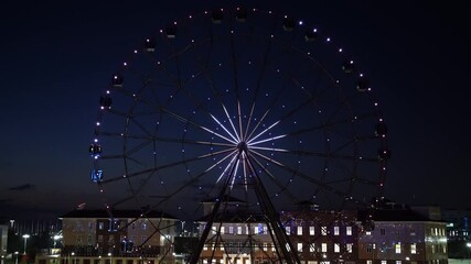 Wall Mural - accelerated. Ferris wheel with glowing multicolored lights against the night sky