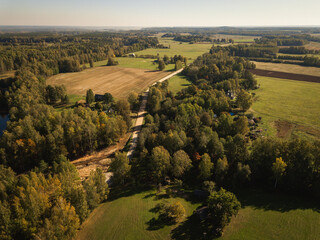 Wall Mural - aerial drone shot view look from above of a road through the forest and country side 