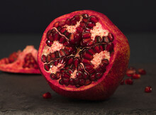 
Pomegranate Fruit. Revealed Tropical Red Fruit On A Black Background. Pomegranate Seeds Open