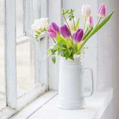 beautiful tulips on old white windowsill