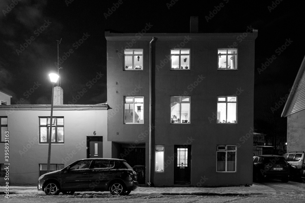Leere Strassen und hell erleuchtete Fenster in Reykjavik. Die sonst belebte Innenstand ist wegen der Corona-Maßnahmen und ausbleibenden Tourisen wie leer gefegt. - obrazy, fototapety, plakaty 