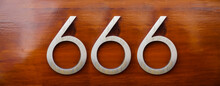 House Number Six Hundred And Sixty Six (666) Embossed In A Metal Plate. The Number Of The Beast. Number Of Devil, Satan On Wooden Door Background