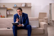 © Elnur - Young male employee working from home in pandemic concept
