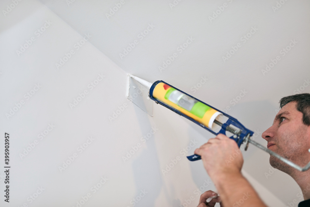 Handyman using silicone sealant adhesive bond for fixing household ...