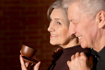 Wall Mural - Happy senior couple posing with cup of coffee