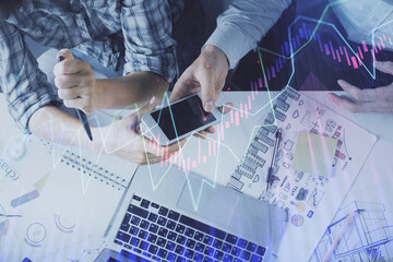 Double exposure of forex graph drawing and man and woman working together holding and using a mobile device. Trade concept.