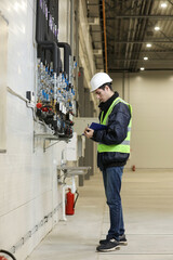 Wall Mural - Portrait of a Caucasian man , factory engineer in work clothes controlling the work process at the helicopter manufacture.