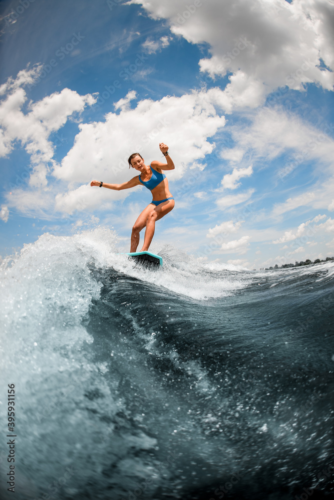 Sexy woman in blue swimsuit having fun on the board on the river