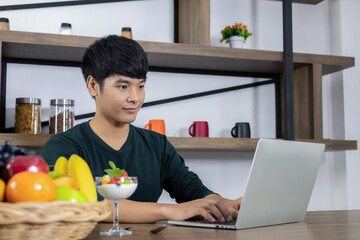 Young Asian man is sitting in a modern dining room