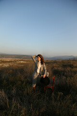 Wall Mural - beautiful woman with dark hair in elegant clothes posing in autumn field