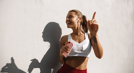 Wall Mural - Sporty woman doing cardio workout with music. Female athelte dancing listening songs in earphones during morning run. doing jogging