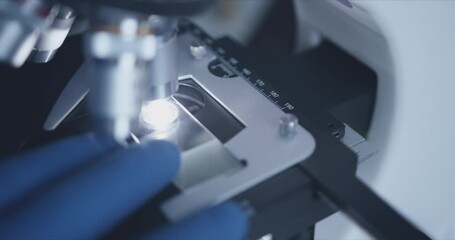 Wall Mural - close-up shot of sample slide and microscope with metal lens at laboratory.