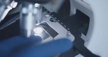 Wall Mural - close-up shot of sample slide and microscope with metal lens at laboratory.