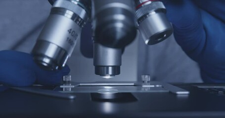 Wall Mural - close-up shot of sample slide and microscope with metal lens at laboratory.