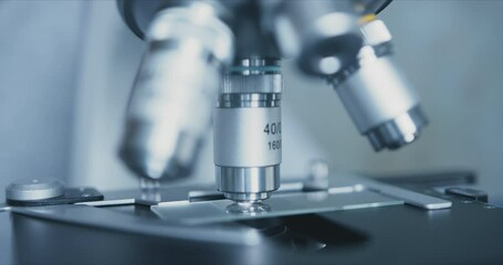 Wall Mural - close-up shot of sample slide and microscope with metal lens at laboratory.