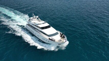 Wall Mural - Aerial tracking top down video of luxury yacht cruising in deep blue open ocean sea