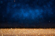 Blurred abstract blue background with gold glitter