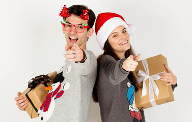 Young couple guy girl in Christmas sweater Santa hat posing isolated on white wall background. New Year celebration party concept. Mock up copy space