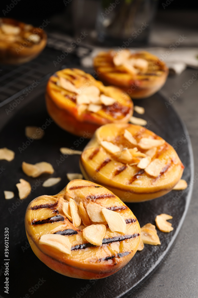 Delicious grilled peaches with almond flakes on grey table, closeup - obrazy, fototapety, plakaty 