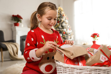 Sticker - Cute little girl taking gift from Christmas advent calendar at home