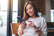 © Farknot Architect - Closeup image of a beautiful young asian woman holding and using smart phone