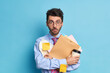 © wayhome.studio - Shocked student with thick bristle prepares for studying courses holds papers and disposable cup of coffee dressed formally. Stunned employee prepares accounting project for boss works in office