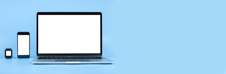 Mockup image computer, smart watch, cell phone with blank screen for typing text in workplace on desk at office. Conception design creative work space on blue background. Modern digital devices