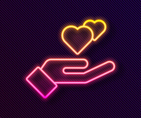 Poster - Glowing neon line Heart in hand icon isolated on black background. Hand giving love symbol. Valentines day symbol. Vector.