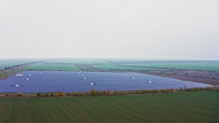 Wall Mural - Huge solar power plant to use solar energy in a picturesque green field in Ukraine. Aerial UHD 4K drone realtime video, shot in 10bit HLG and colorized