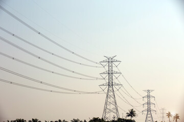 High-voltage transmission tower and electricity voltage wiring cable with sky background.