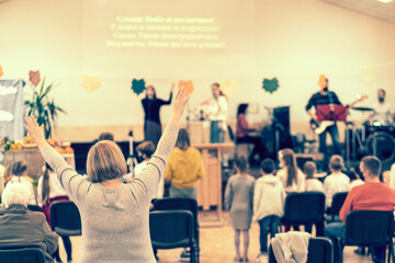 Wall Mural - People praying in a church. soft focus of christian people group raise hands up worship God Jesus Christ together in church. toned