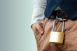Close-up of a gold padlock hanging from a man's belt. The concept of marital fidelity, celibacy, treason, chastity belt.